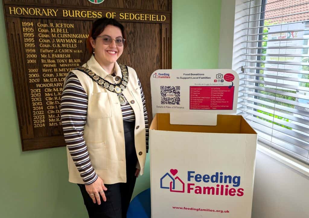 Mayor of Sedgefield promoting a Feeding Families donation box inside the town council office. Mayor of Sedgefield promoting a Feeding Families donation box inside the town council office.